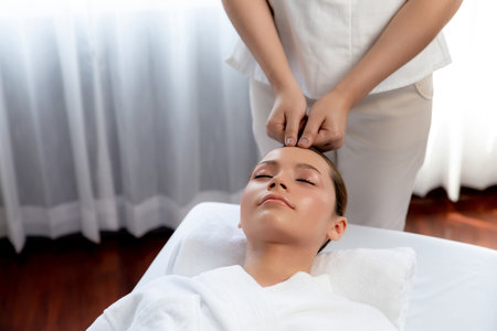 Caucasian woman enjoying relaxing anti-stress head massage and pampering facial beauty skin recreation leisure in dayspa modern light ambient at luxury resort or hotel spa salon. Quiescentの写真素材
