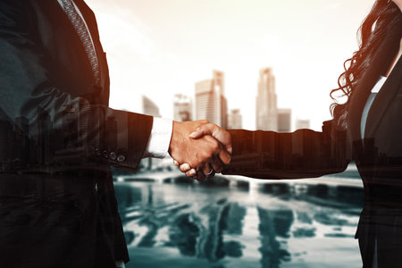 Double exposure image of business people handshake on city office building in background show partnership success of business deal. Concept of corporate teamwork, trust partner and work agreement. udsの写真素材