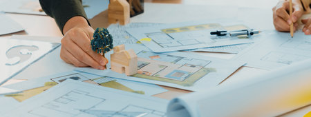 Sustainable eco house blueprint was placed on meeting table with architectural paper work scatter...