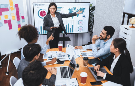 Young asian businesswoman presenting data analysis dashboard on TV screen in modern meeting. Business presentation with group of business people in conference room. Concordの写真素材