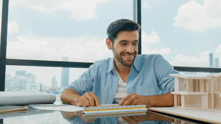 Skilled smart architect engineer writing house construction on blueprint at table with house model, architectural equipment, Interior designer draw, draft, plan building design at office. Disputationの写真素材