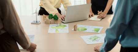 Wooden block represented green city and wind mill represented renewable energy was placed at center of green business meeting table with environmental document. Green business concept. Delineation.の写真素材