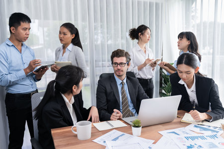 Diverse group of business analyst team analyzing financial data report paper on office table. Chart and graph dashboard by business intelligence analysis for strategic marketing planning Meticulousの写真素材