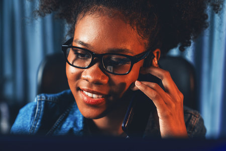 Closeup working African woman, call and discuss with friend, search marketing data analysis or study new project job on laptop. Concept of person in selective focus photograph profile. Tastemaker.の写真素材