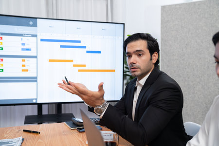 Project manager planning schedules for business task at meeting room, Gantt chart software show on TV screen. Multi ethnic diversity business people and modern business project management. Habilimentの写真素材