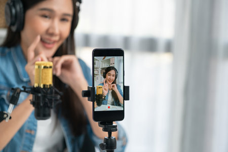 Host channel Asian influencer talking in broadcast wearing headsets on social media live on...