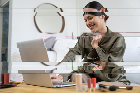 Young happy Asian woman buy product by online shopping at home while ordering items from the internet with credit card online payment protected by uttermost cyber security from online store platformの写真素材