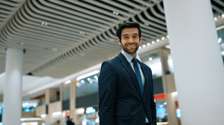 Smiling business man looking at camera while standing at white background. Closeup of successful man smiling at camera while wearing business suit. Happy executive manager look at camera. Exultant.の写真素材