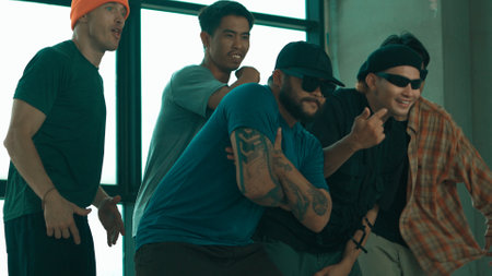 Skilled hipster pose at camera with multicultural friend at building. Group of energetic hip-hop...
