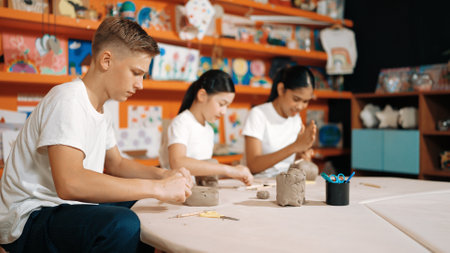 Group of happy smart diverse student working with clay art at pottery workshop. Multicultural...