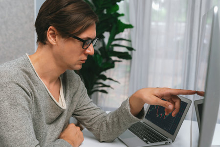 Smart stock investors pointing interesting market stock exchange on pc with laptop screen. Financial technology dynamic investment plan focusing data graph on monitor at modern workplace. Pecuniary.の写真素材