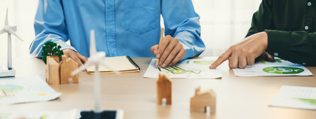 Business people invest in green business plan at meeting room on table with house model and wind...