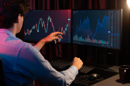 Working young business trader pointing on market stock graph data planning in real time monitor with...