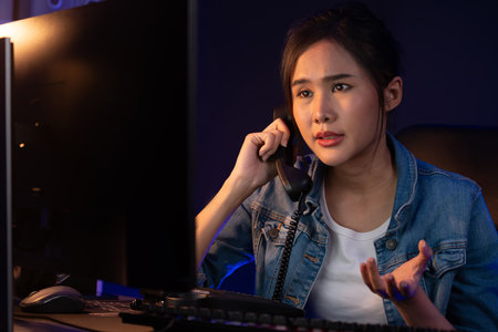 Young beautiful Asian creative woman calling on phone desk to customer or coworker explaining...