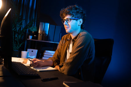 Young businessman concentrating on pc for creative startup project job at neon light modern office....