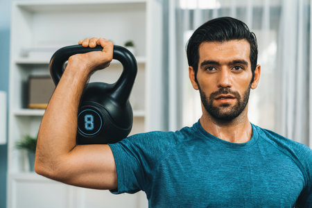 Athletic body and active sporty man lifting kettlebell weight for effective targeting muscle gain at...