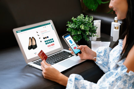Young woman order or purchase product on internet using laptop and make transaction payment by smartphone. Online shopping lifestyle with credit card via internet banking on mobile application. Blitheの写真素材