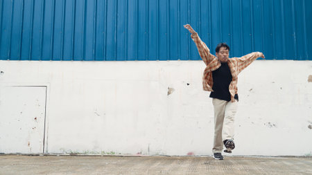 Hispanic funny choreographer dancing in hip hop style. Young happy break dancer perform b-boy dance. Motion shot of funny man practicing street dancing. Outdoor sport 2024. Modern dance. Endeavor.の写真素材