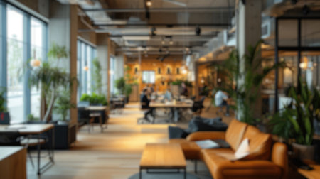 Defocused image of a lively modern co-working area with people and indoor plants. Resplendent.