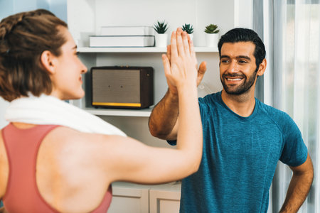 Athletic body and sporty young couple or workout buddy in sportswear high five after successful in...
