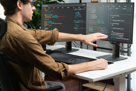IT developer working online software development on pc monitors at modern home office on coding...