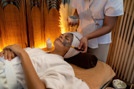 Serene ambiance of spa salon, woman customer indulges in rejuvenating with charcoal face cream...