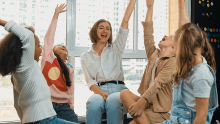 Caucasian teacher and diverse students raised hands at classroom. Young instructor and multicultural children cheering and encourage. Represented voting, asking,answering,volunteering. Erudition.の写真素材