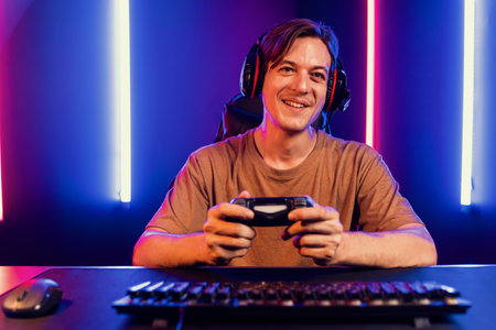 Enjoy smart gaming streamer with control joystick, playing game online of live streaming social media group with team skilled players on computer at modern technology cyber neon light room. Pecuniary.の写真素材