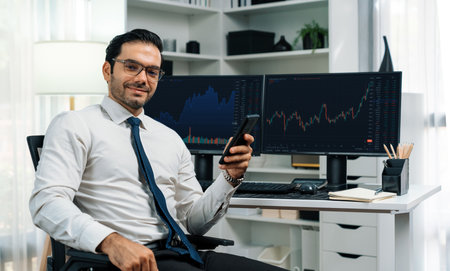 Profile of successful in smiling trader businessman looking at camera with holding phone two stock...