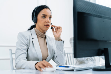 African American businesswoman wearing headset working in office to support remote crucial customer...