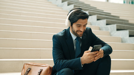 Smart business man listening and enjoy music while wear headphone. Profession project manager smiling while getting good news, getting promotion, increasing sales. Relaxing man enjoy music. Exultant.の写真素材