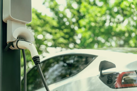 EV electric vehicle recharging battery from EV charging station in national park or outdoor forest scenic. Natural protection with eco friendly EV car travel in the summer woods. Exaltの写真素材