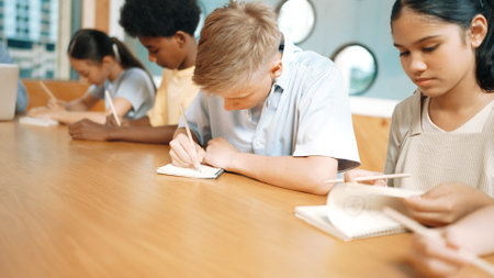 Young smart teenager writing and talking about topic at classroom. Diverse highschool student taking...
