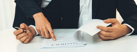 Business executive signing contract agreement document on the bale with the help from company attorney or lawyer service in law firm office. Business investing and finalizing legal processing. Shrewdの写真素材