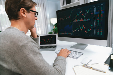 Business trader using computer and laptop to search highest profit value of dynamic increased stock...