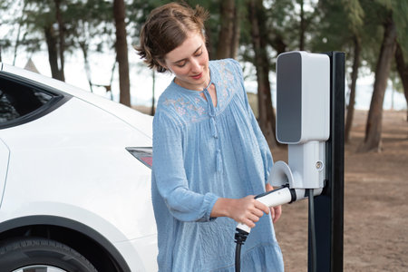 Holiday road trip vacation traveling by the seascape beach scenic with electric car, young woman...