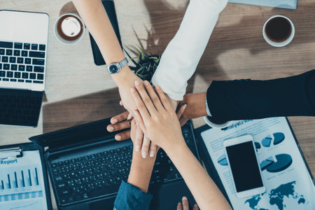 Businessmen and businesswomen joining hands in group meeting at multicultural office room showing teamwork, support and unity in business. Diversity workplace and corporate people working concept. udsの写真素材