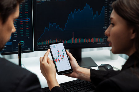 Focusing on phone with discussing dynamic stock market in two business traders online website...