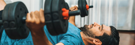 Athletic body and active sporty man lifting dumbbell weight for effective targeting muscle gain at...
