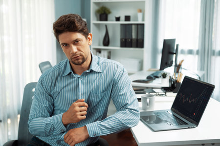 Profile of smart investor stock in trader looking at camera in dynamic exchange on laptop screen of...