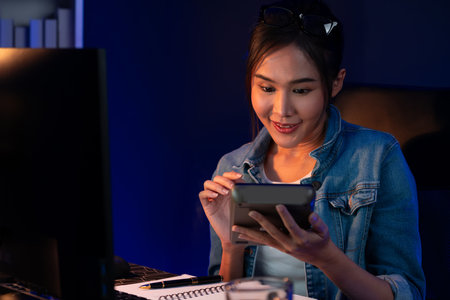 Successful young beautiful asian creative calculating digit of profit of sales target report on...