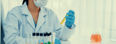 Laboratory researcher develop new medicine or cure using colorful chemical liquid in lab tube....