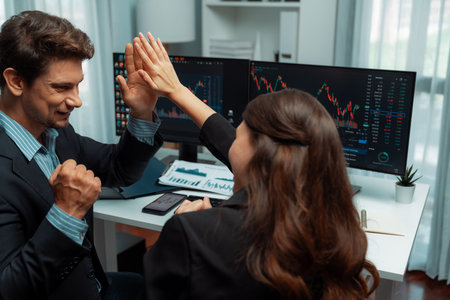 Successful in two business traders making hands high five with fist up to earn highest profit stock...