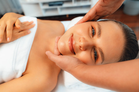 Caucasian woman enjoying relaxing anti-stress head massage and pampering facial beauty skin recreation leisure in dayspa modern light ambient at luxury resort or hotel spa salon. Quiescentの写真素材