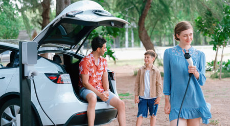 Family road trip vacation with electric vehicle, lovely family recharge EV car with green and clean energy. Natural and eco friendly car travel for sustainable environment. Perpetualの写真素材