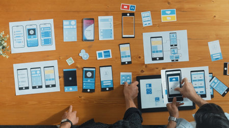 Top view of software developer working on Ux Ui design while team working together to brainstorm and develop wireframe prototype designing at creative digital company. Teamwork concept. Convocation.の写真素材