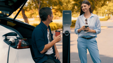 EV car recharging electricity for battery by lovey couple traveling during their road trip travel by...
