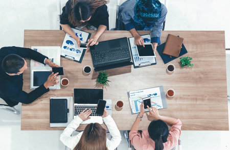 Top view of businessman executive in group meeting with other businessmen and businesswomen in modern office with laptop computer, coffee and document on table. People corporate business team udsの写真素材