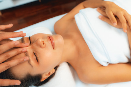 Caucasian woman enjoying relaxing anti-stress head massage and pampering facial beauty skin recreation leisure in dayspa modern light ambient at luxury resort or hotel spa salon. Quiescentの写真素材