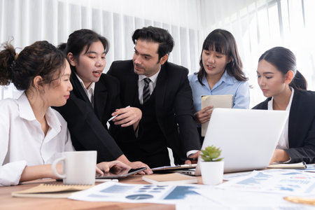 Diverse group of business analyst team analyzing financial data report paper on office table. Chart and graph dashboard by business intelligence analysis for strategic marketing planning Meticulousの写真素材